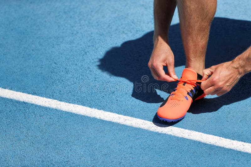 Αθλητής sprinter που παίρνει έτοιμος να τρέξει να εμπλέξει τις δαντέλλες παπουτσιών στις τρέχοντας διαδρομές σταδίων Δρομέας ατόμ στοκ φωτογραφία με δικαίωμα ελεύθερης χρήσης Αθλητής sprinter που παίρνει έτοιμος να τρέξει να εμπλέξει τις δαντέλλες παπουτσιών στις τρέχοντας διαδρομές σταδίων Δρομέας ατόμ στοκ φωτογραφία με δικαίωμα ελεύθερης χρήσης