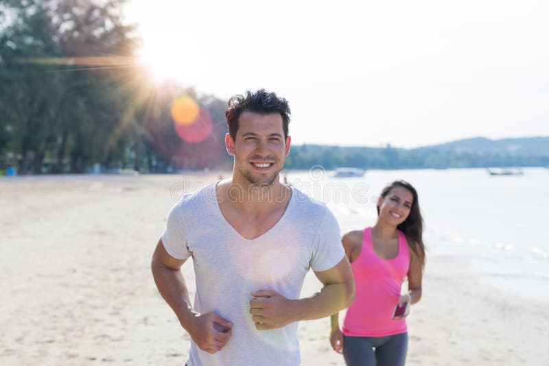 Αθλητικοί δρομείς Jogging ανδρών και γυναικών ζεύγους τρέχοντας στην παραλία που επιλύουν την ευτυχή κατάλληλη αρσενική και θηλυκ στοκ φωτογραφία με δικαίωμα ελεύθερης χρήσης