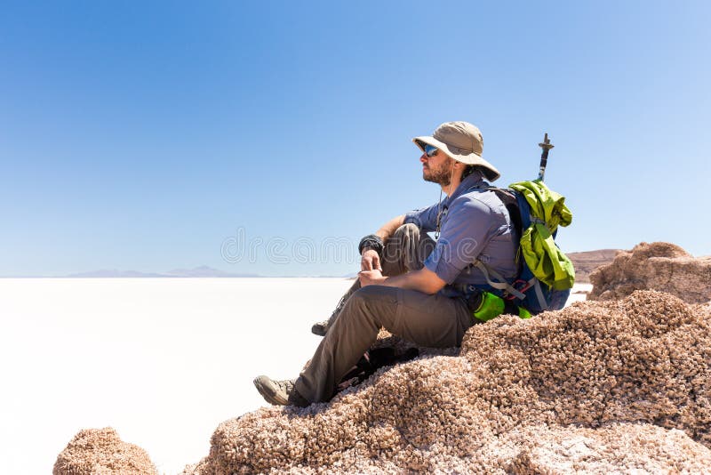 Αιχμή βουνών συνεδρίασης τουριστών backpacker, επάνω από την αλατισμένη έρημο, Bol στοκ εικόνα Αιχμή βουνών συνεδρίασης τουριστών backpacker, επάνω από την αλατισμένη έρημο, Bol στοκ εικόνα