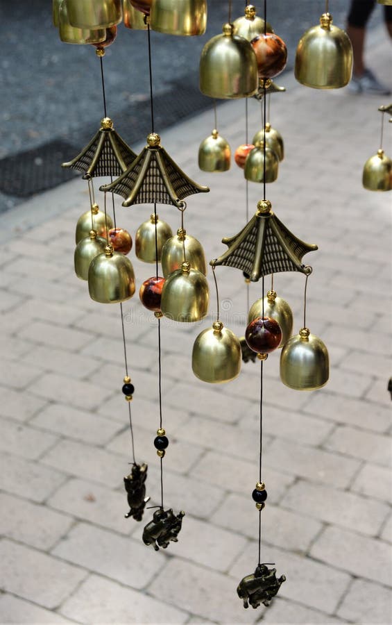 Wind chimes are hanging outside of a shop. Wind chimes are hanging outside of a shop