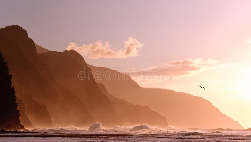 Receding headlands of Kauai coastline illuminated at sunset over a stormy sea with a distant bird. Receding headlands of Kauai coastline illuminated at sunset over a stormy sea with a distant bird