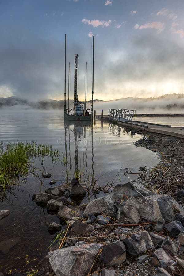 A small barge by a dock at sunrise in Hauser Lake, Idaho. A small barge by a dock at sunrise in Hauser Lake, Idaho.