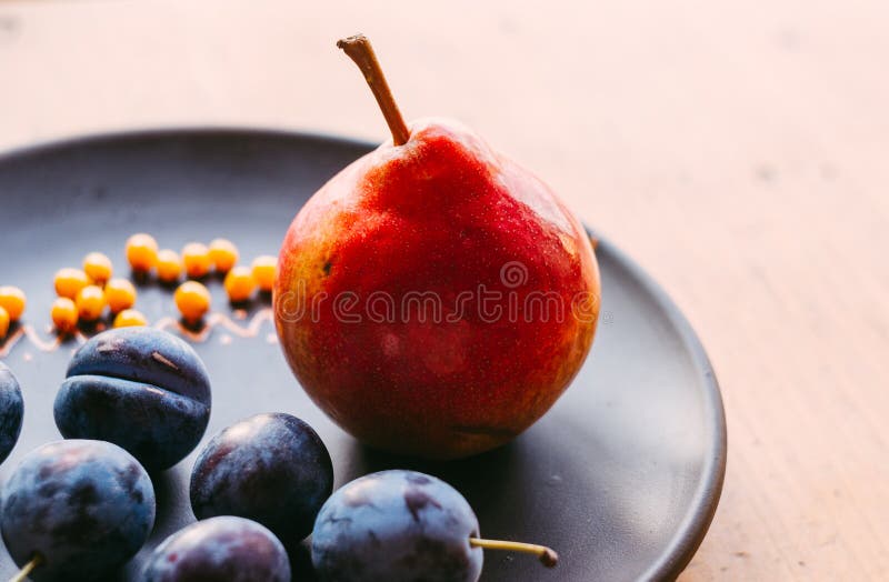 ακόμα ζωή - juicy μπλε δαμάσκηνα, μεγάλο ώριμο αχλάδι, και μούρα λευκαγκαθιών σε ένα κεραμικό πιάτο σε ένα ξύλινο υπόβαθρο στοκ εικόνες με δικαίωμα ελεύθερης χρήσης ακόμα ζωή - juicy μπλε δαμάσκηνα, μεγάλο ώριμο αχλάδι, και μούρα λευκαγκαθιών σε ένα κεραμικό πιάτο σε ένα ξύλινο υπόβαθρο στοκ εικόνες με δικαίωμα ελεύθερης χρήσης