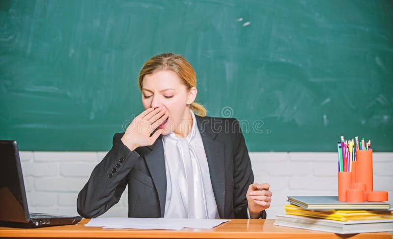 Need for sleep. High level fatigue. Exhausting work in school causes fatigue. Teacher woman sleepy face tired sit table classroom chalkboard background. Life of teacher exhausting. Yawning teacher. Need for sleep. High level fatigue. Exhausting work in school causes fatigue. Teacher woman sleepy face tired sit table classroom chalkboard background. Life of teacher exhausting. Yawning teacher.