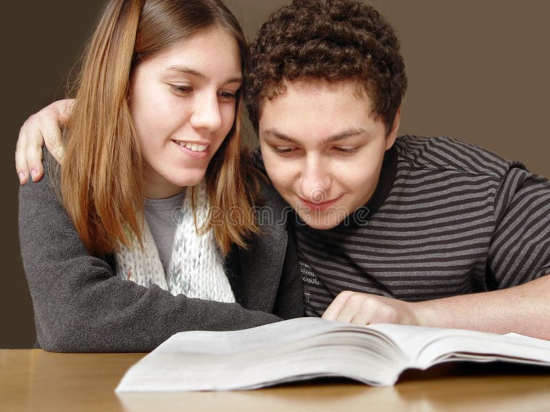 2 teenagers reading a book. 2 teenagers reading a book