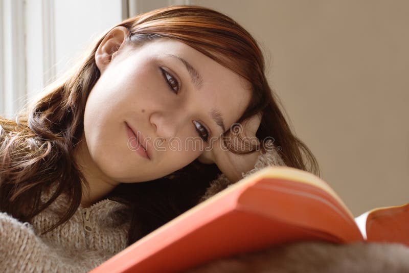 Beautiful girl relaxing whilst reading a book. Beautiful girl relaxing whilst reading a book