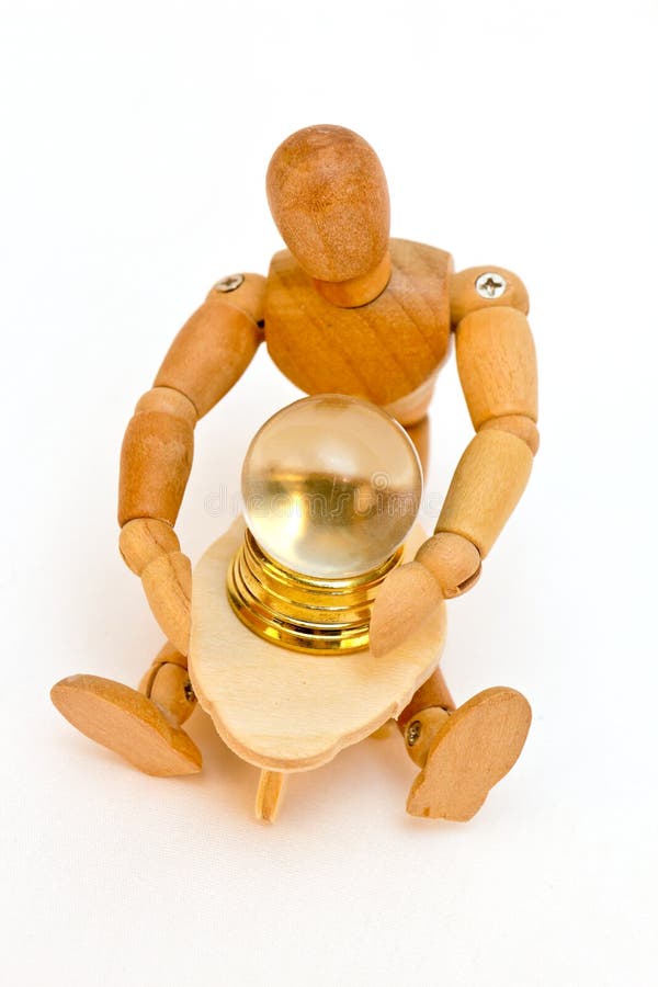 Wooden artist's drawing mannequin with a miniature crystal ball and table. Concept of psychic, medium, or fortune teller. White isolated background. Wooden artist's drawing mannequin with a miniature crystal ball and table. Concept of psychic, medium, or fortune teller. White isolated background.