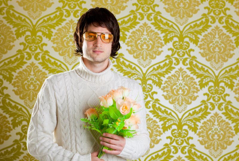 Retro hip young man vintage glasses holding valentines flowers bouquet on wallpaper. Retro hip young man vintage glasses holding valentines flowers bouquet on wallpaper