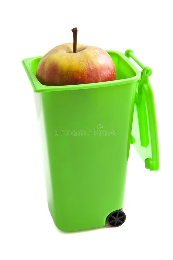 Green garbage container with apple isolated over white. Green garbage container with apple isolated over white