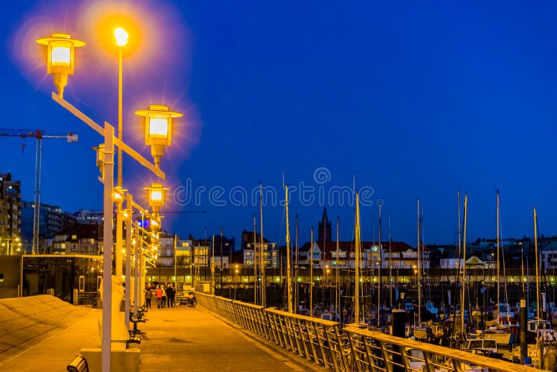 Αναμμένος lampposts τη νύχτα στο λιμάνι του blankenberge, δημοφιλής πόλη στο Βέλγιο, αρχιτεκτονική πόλεων το βράδυ