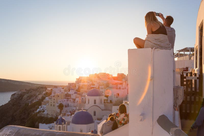 Ανατολή προσοχής ζεύγους και λήψη των φωτογραφιών διακοπών στο νησί Santorini, Ελλάδα στοκ φωτογραφίες με δικαίωμα ελεύθερης χρήσης