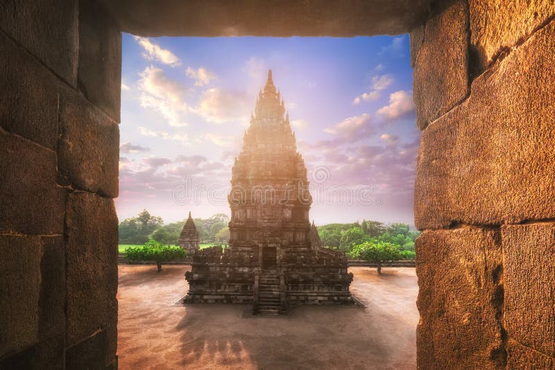 Beautiful buildings of ancient Prambanan or Rara Jonggrang Hindu temple complex against shining morning sun on background. Java, Indonesia. Amazing touristic landmark at sunrise. Beautiful buildings of ancient Prambanan or Rara Jonggrang Hindu temple complex against shining morning sun on background. Java, Indonesia. Amazing touristic landmark at sunrise