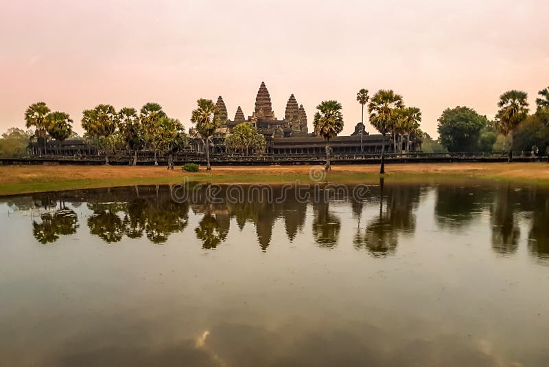 Sunrise view of popular tourist attraction ancient temple complex Angkor Wat with reflected in lake Siem Reap, Cambodia. Sunrise view of popular tourist attraction ancient temple complex Angkor Wat with reflected in lake Siem Reap, Cambodia