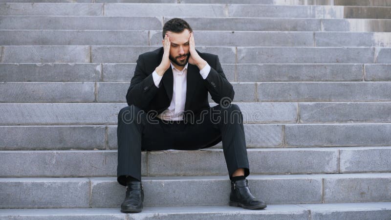 Ανατρέψτε το νέο επιχειρησιακό άτομο που έχει την πίεση και που κάθεται στα σκαλοπάτια στην οδό Επιχειρηματίας που έχει την έννοι στοκ εικόνες με δικαίωμα ελεύθερης χρήσης Ανατρέψτε το νέο επιχειρησιακό άτομο που έχει την πίεση και που κάθεται στα σκαλοπάτια στην οδό Επιχειρηματίας που έχει την έννοι στοκ εικόνες με δικαίωμα ελεύθερης χρήσης