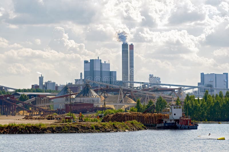 Ανεφοδιασμός της ξυλείας στο riverfront papermill στοκ φωτογραφία με δικαίωμα ελεύθερης χρήσης Ανεφοδιασμός της ξυλείας στο riverfront papermill στοκ φωτογραφία με δικαίωμα ελεύθερης χρήσης