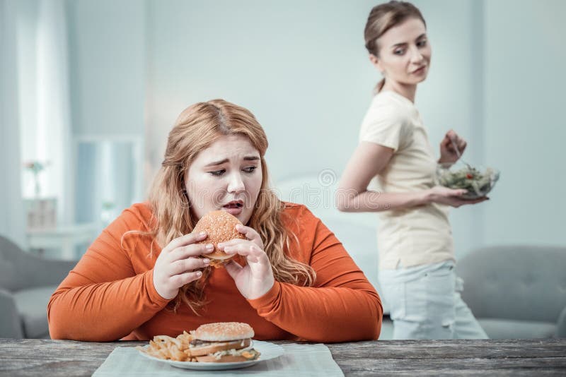 Ανησυχημένο μακρυμάλλες κορίτσι που πηγαίνει να φάει burger