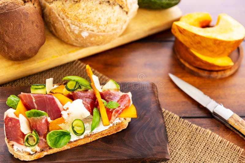 ανοιχτό σάντουιτς με παρμεζάνα iberico ham και κατσίκα τυρί zucchini κολοκύθα βασιλικό σε ξύλο ζύμης και χορδή στοκ φωτογραφία με δικαίωμα ελεύθερης χρήσης