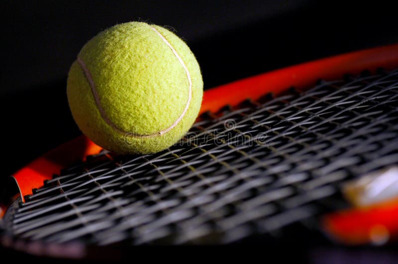 Tennis equipment - ball and racket on black. Soft light, shallow depth of field. Tennis equipment - ball and racket on black. Soft light, shallow depth of field.