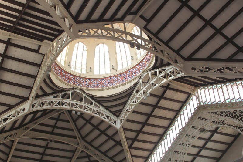 Ceiling of the Mercado Central market in Valencia in Art Nouveau architecture style. Spain. Spanish. At this indoor market they sell tapas, fruits, vegetables, fish, seafood, meat, jamon serrano. This building is antique and 100 years old. Ceiling of the Mercado Central market in Valencia in Art Nouveau architecture style. Spain. Spanish. At this indoor market they sell tapas, fruits, vegetables, fish, seafood, meat, jamon serrano. This building is antique and 100 years old.