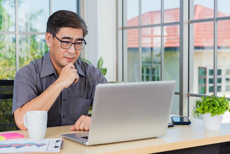 ανώτερος επιχειρηματίας που εργάζεται online σε σύγχρονο φορητό υπολογιστή στοκ φωτογραφίες με δικαίωμα ελεύθερης χρήσης