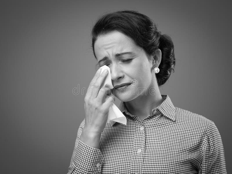 1950s depressed woman crying and drying her tears with an handkerchief. 1950s depressed woman crying and drying her tears with an handkerchief