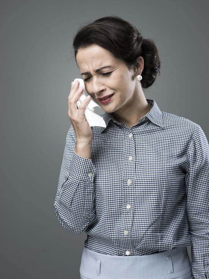 1950s depressed woman crying and drying her tears with an handkerchief. 1950s depressed woman crying and drying her tears with an handkerchief