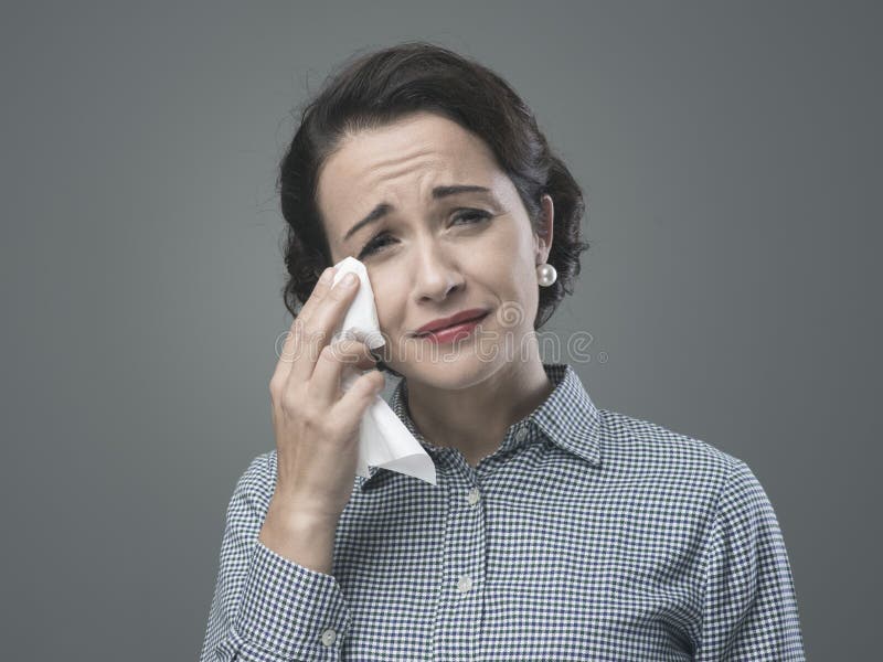 1950s depressed woman crying and drying her tears with an handkerchief. 1950s depressed woman crying and drying her tears with an handkerchief