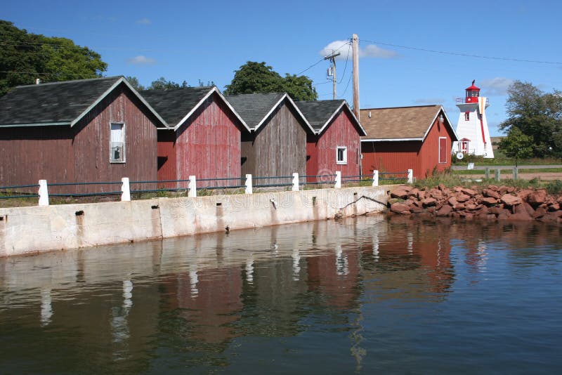 Fishing shacks and lighthouse at the wharf in Victoria-by-the-Sea, Prince Edward Island. Fishing shacks and lighthouse at the wharf in Victoria-by-the-Sea, Prince Edward Island.