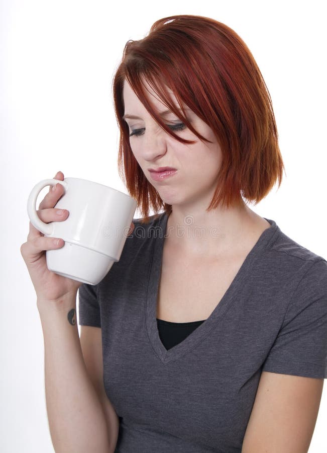 Redhead woman has a disappointing cup of morning coffee. Redhead woman has a disappointing cup of morning coffee