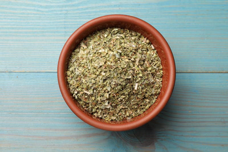 Αποξηραμένο oregano σε μπολ σε ανοιχτό μπλε ξύλινο τραπέζι πάνω όψη στοκ φωτογραφίες με δικαίωμα ελεύθερης χρήσης