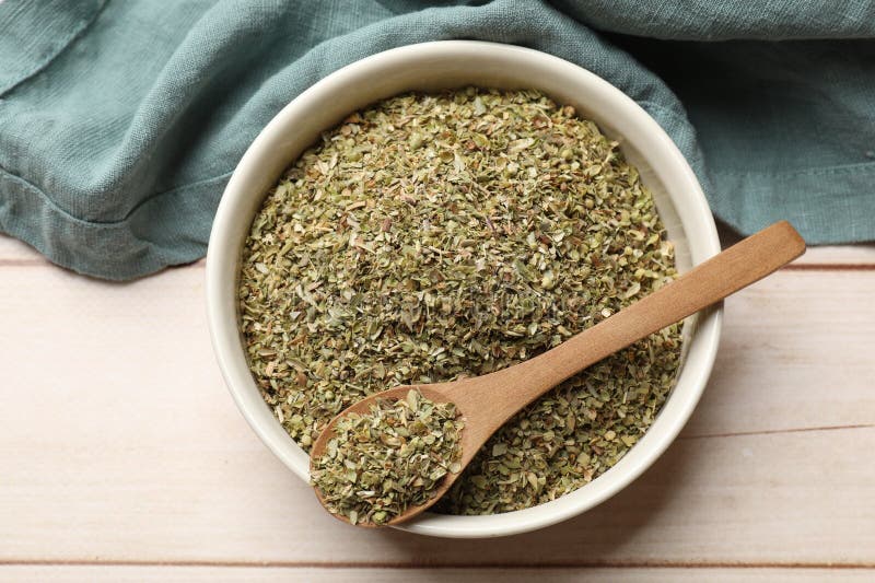 Αποξηραμένο oregano σε μπολ και κουτάλι σε ξύλινη επιφάνεια τραπεζιού στοκ φωτογραφία με δικαίωμα ελεύθερης χρήσης