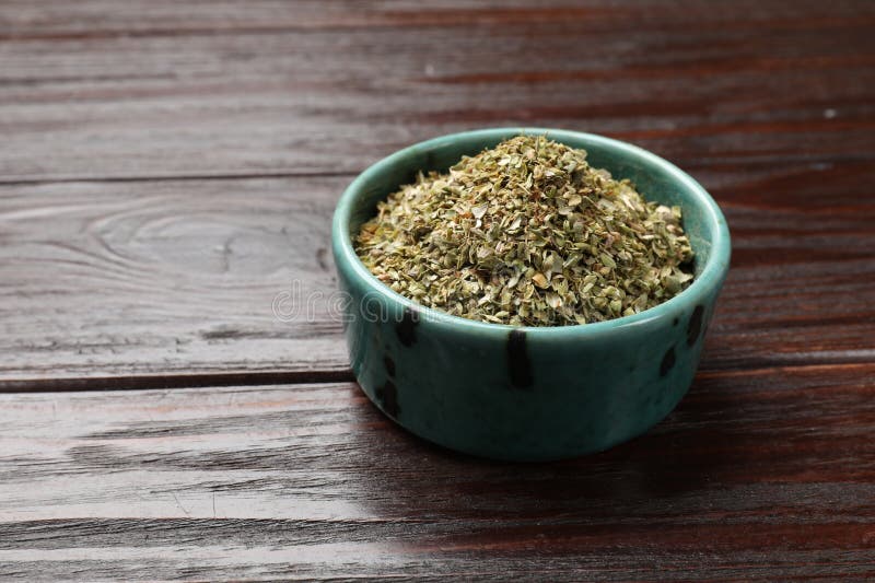 Αποξηραμένο oregano σε μπολ σε ξύλινο τραπέζι κοντά. Χώρος κειμένου στοκ φωτογραφία με δικαίωμα ελεύθερης χρήσης