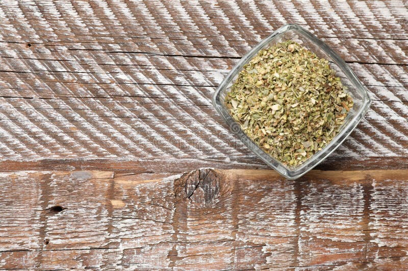 Αποξηραμένο oregano σε μπολ πάνω σε ξύλινο τραπέζι. στοκ εικόνα