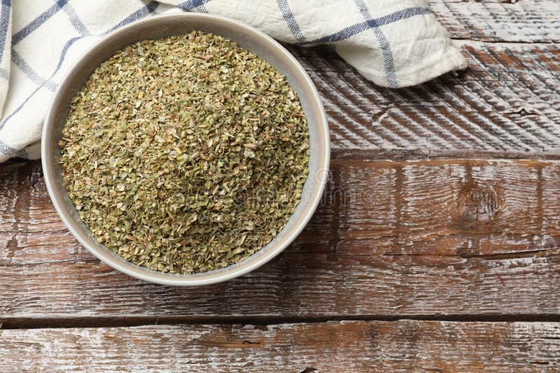 Αποξηραμένο oregano σε μπολ πάνω σε ξύλινο τραπέζι. Χώρος κειμένου στοκ εικόνες