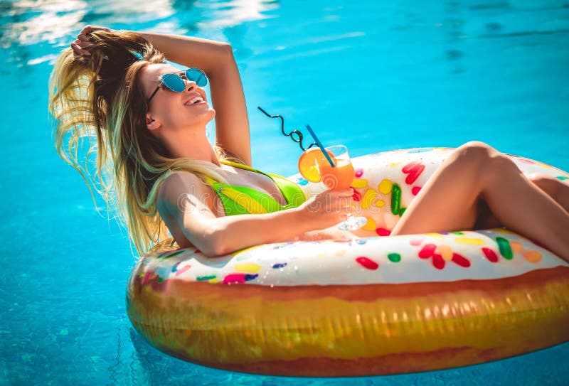 Απόλαυση της suntan γυναίκας στο μπικίνι στο διογκώσιμο στρώμα στην πισίνα στοκ φωτογραφία με δικαίωμα ελεύθερης χρήσης Απόλαυση της suntan γυναίκας στο μπικίνι στο διογκώσιμο στρώμα στην πισίνα στοκ φωτογραφία με δικαίωμα ελεύθερης χρήσης