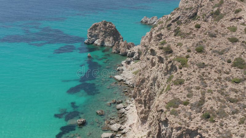 αργή εναέρια πτήση πάνω από το ελληνικό νησί μίλος τυρκουάζ μπλε ωκεανός με βραχώδη ακτή γκρεμού
