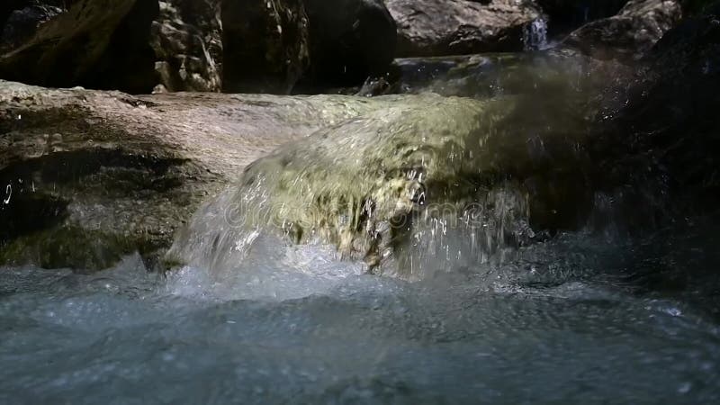 αργή κίνηση νερού που ρέει μέσα από τους βράχους. φιλμ μικρού μήκους