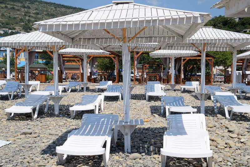 Αργόσχολοι ήλιων κάτω από έναν θόλο Υποδομή της παραλίας, προστασία από τον ήλιο στοκ εικόνα με δικαίωμα ελεύθερης χρήσης Αργόσχολοι ήλιων κάτω από έναν θόλο Υποδομή της παραλίας, προστασία από τον ήλιο στοκ εικόνα με δικαίωμα ελεύθερης χρήσης