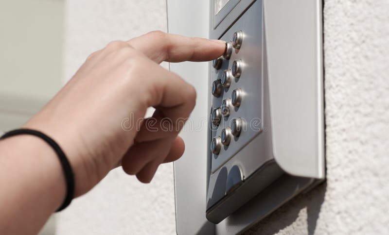Αριθμητική κωδικοποιώντας συσκευή πορτών στο κτήριο, με το θηλυκό χέρι στοκ εικόνα με δικαίωμα ελεύθερης χρήσης Αριθμητική κωδικοποιώντας συσκευή πορτών στο κτήριο, με το θηλυκό χέρι στοκ εικόνα με δικαίωμα ελεύθερης χρήσης