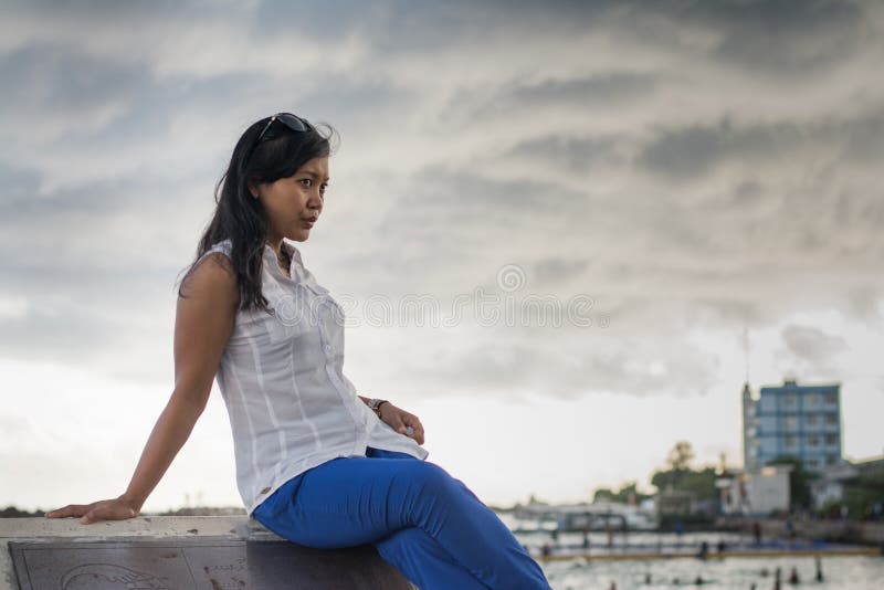 Pretty asian woman sitting under dark cloudy sky at Maldives. Pretty asian woman sitting under dark cloudy sky at Maldives