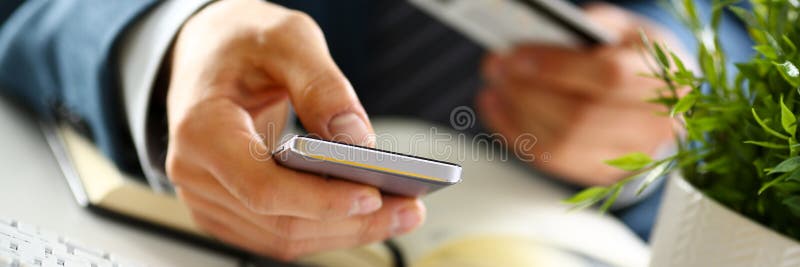 Αρσενικά όπλα κοστουμιών κάρτα και το τηλέφωνο λαβής στην πιστωτική στοκ φωτογραφία με δικαίωμα ελεύθερης χρήσης Αρσενικά όπλα κοστουμιών κάρτα και το τηλέφωνο λαβής στην πιστωτική στοκ φωτογραφία με δικαίωμα ελεύθερης χρήσης