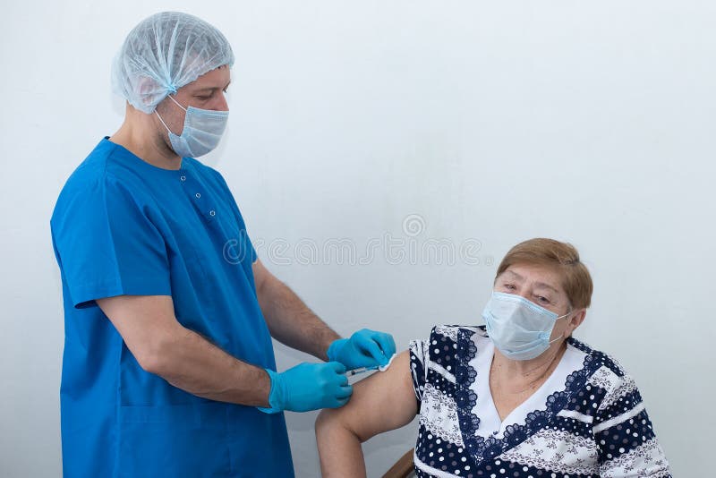 αρσενική νοσοκόμα κάνει ένεση σε ηλικιωμένη γυναίκα εμβολιασμό στοκ φωτογραφία με δικαίωμα ελεύθερης χρήσης