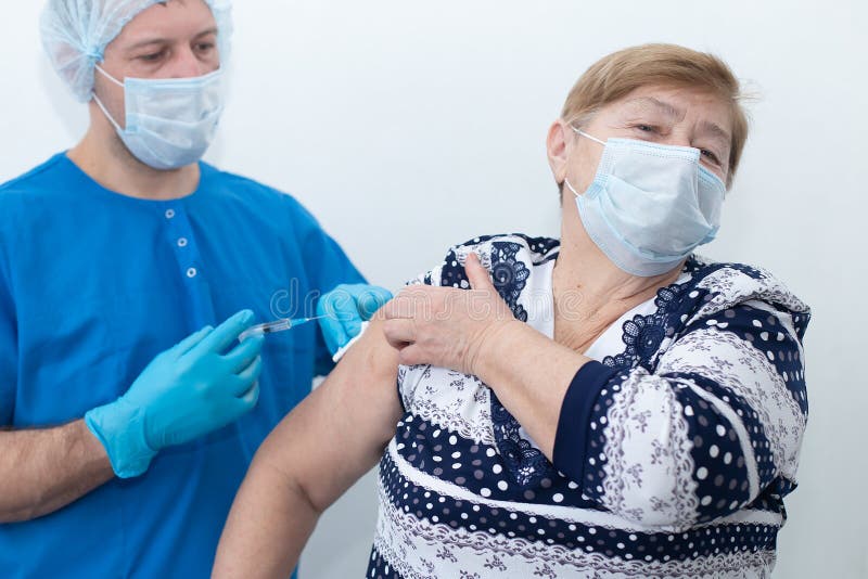 αρσενική νοσοκόμα κάνει ένεση σε ηλικιωμένη γυναίκα εμβολιασμό στοκ φωτογραφία με δικαίωμα ελεύθερης χρήσης