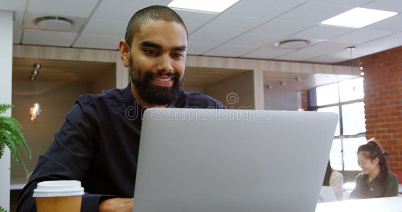 Αρσενικό εκτελεστικό χρησιμοποιώντας lap-top στην καφετέρια 4k γραφείων