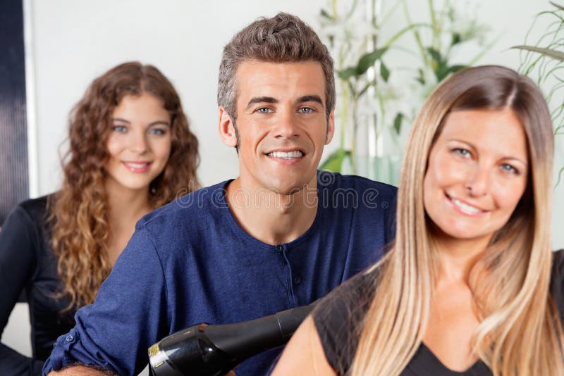 Αρσενικό και θηλυκό Hairstylists στο σαλόνι στοκ εικόνες Αρσενικό και θηλυκό Hairstylists στο σαλόνι στοκ εικόνες