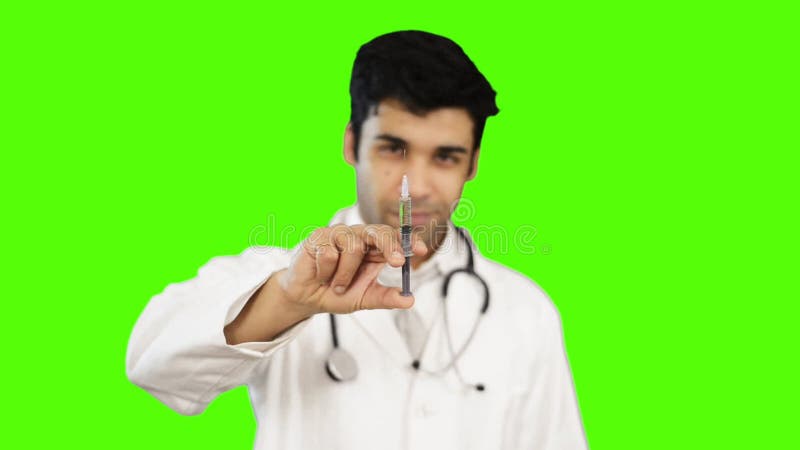 Αρσενικός γιατρός που κρατά μια ιατρική έγχυση στο πράσινο κλίμα