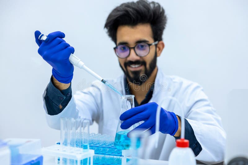 αρσενικός επιστήμονας με ιατρικό ομοιόμορφο χρωστικό χημικό υγρό από την πιπέτα στη γυάλινη φιάλη στοκ φωτογραφία με δικαίωμα ελεύθερης χρήσης