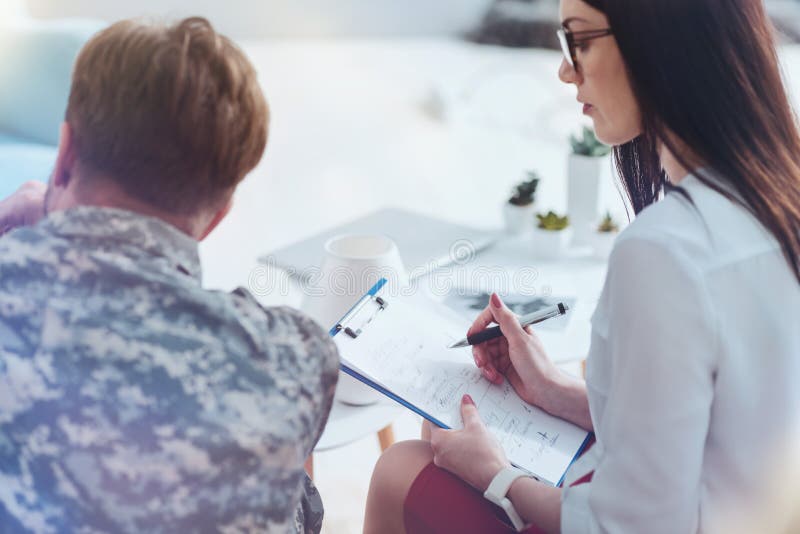 Αρσενικός στρατιώτης και θηλυκός θεράπων κατά τη διάρκεια της συνόδου ψυχοθεραπείας στοκ φωτογραφίες Αρσενικός στρατιώτης και θηλυκός θεράπων κατά τη διάρκεια της συνόδου ψυχοθεραπείας στοκ φωτογραφίες