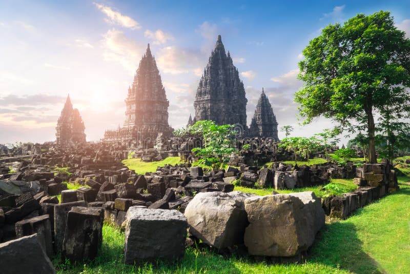 Beautiful buildings of ancient Prambanan or Rara Jonggrang Hindu temple complex against shining morning sun on background. Java, Indonesia. Amazing touristic landmark at sunrise. Beautiful buildings of ancient Prambanan or Rara Jonggrang Hindu temple complex against shining morning sun on background. Java, Indonesia. Amazing touristic landmark at sunrise