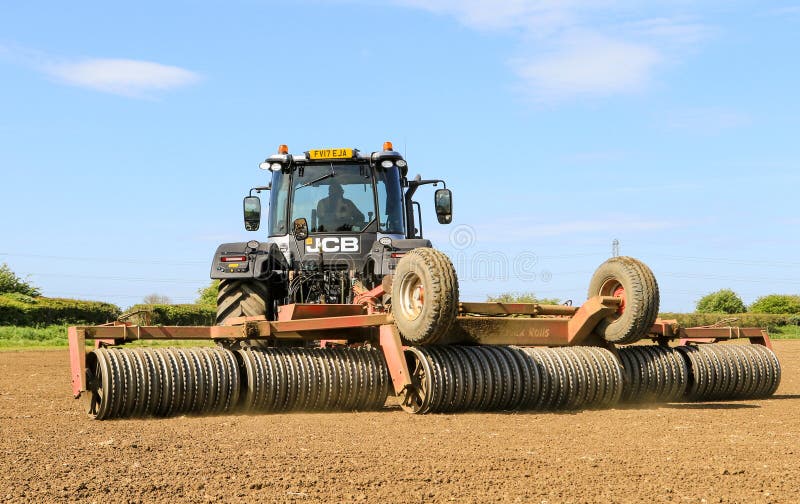 Ασημένιο Jcb fastrac που εργάζεται στον τομέα με τον κύλινδρο στοκ φωτογραφίες